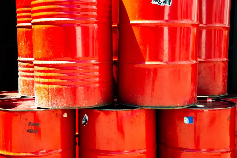 Stacked red steel drums in daylight
